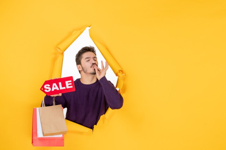 front-view-young-male-holding-little-packages-sale-writing-yellow-background-colors-new-year-present-holiday-gift-christmas_140725-139781
